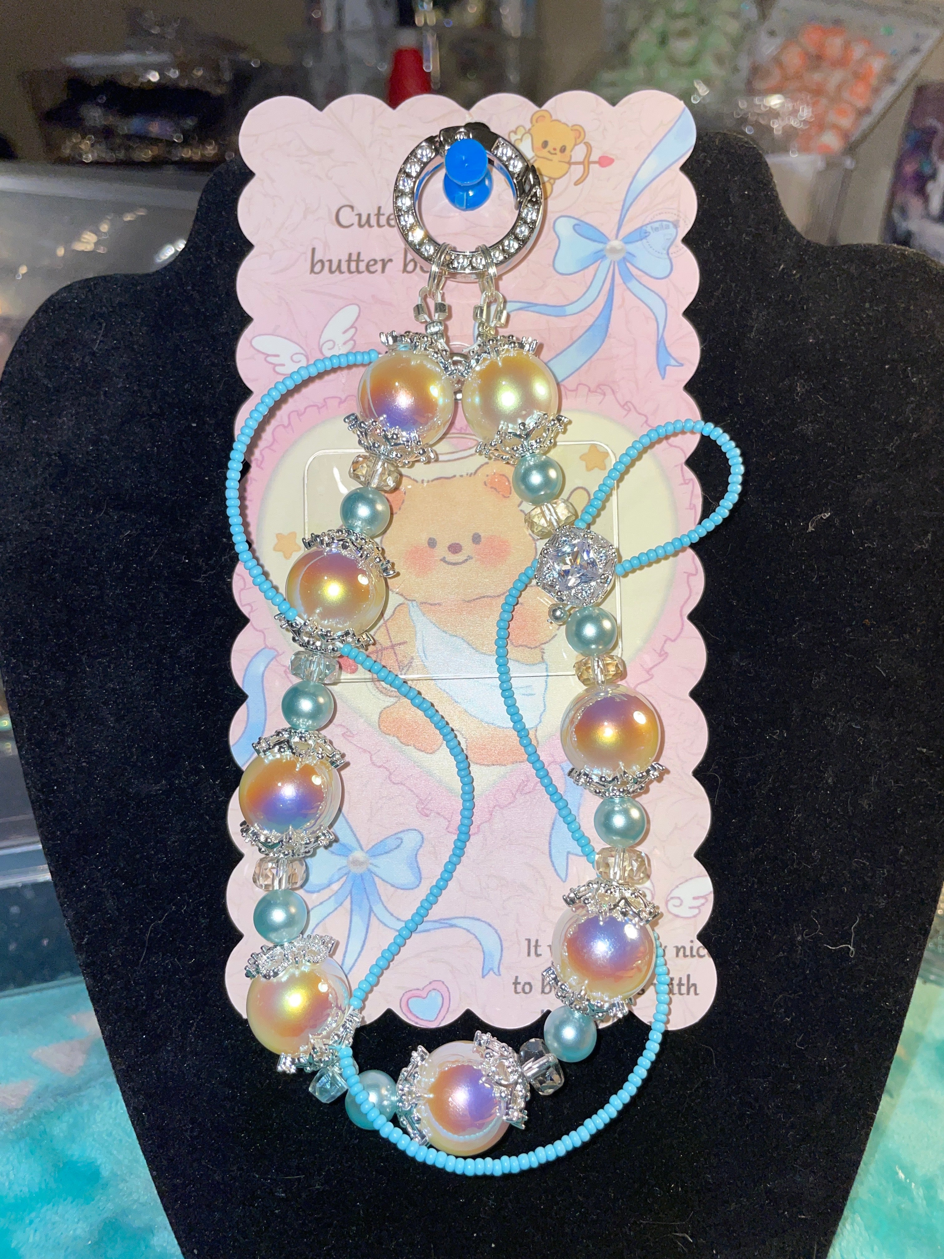 Huge shiny white/blue pearl with a beading around the outline of the keychain that’s handmade.