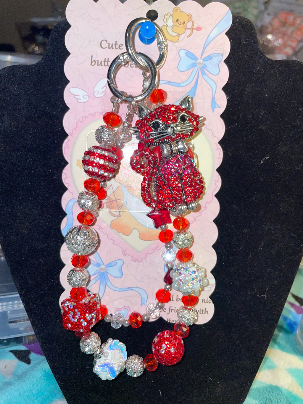 A beautiful luxury cat keychain that is designed with the red/silver design